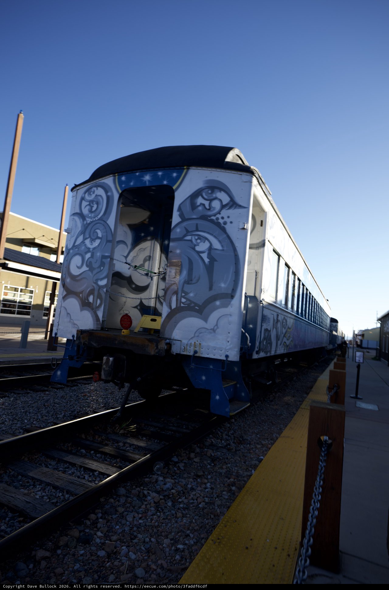 Vintage Train Car with Ornate Blue Artwork at Station