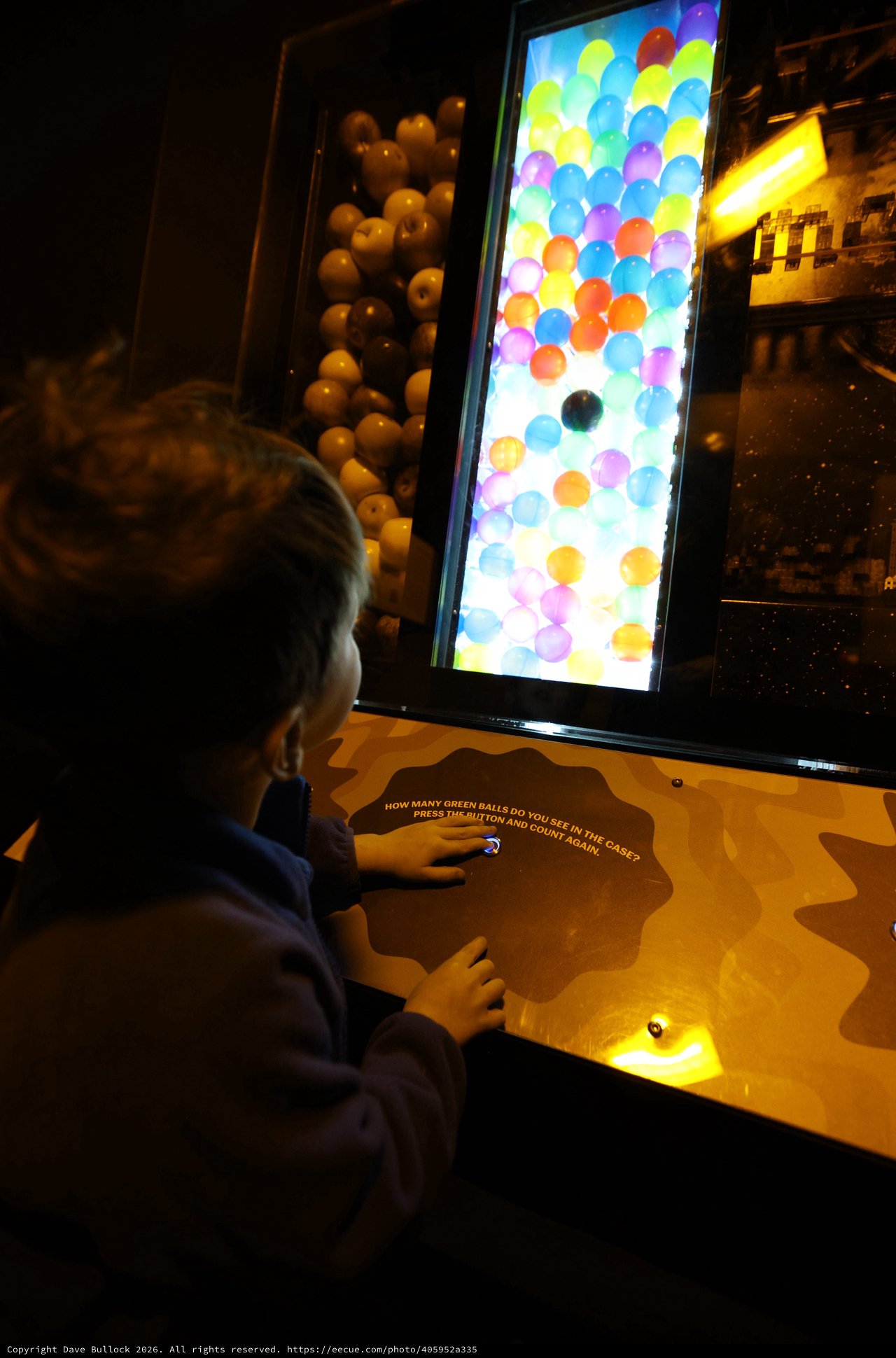 Child Playing Interactive Ball Counting Game at Science Museum