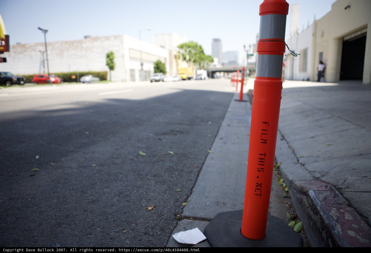 Lone Traffic Cone on a Busy Urban Street