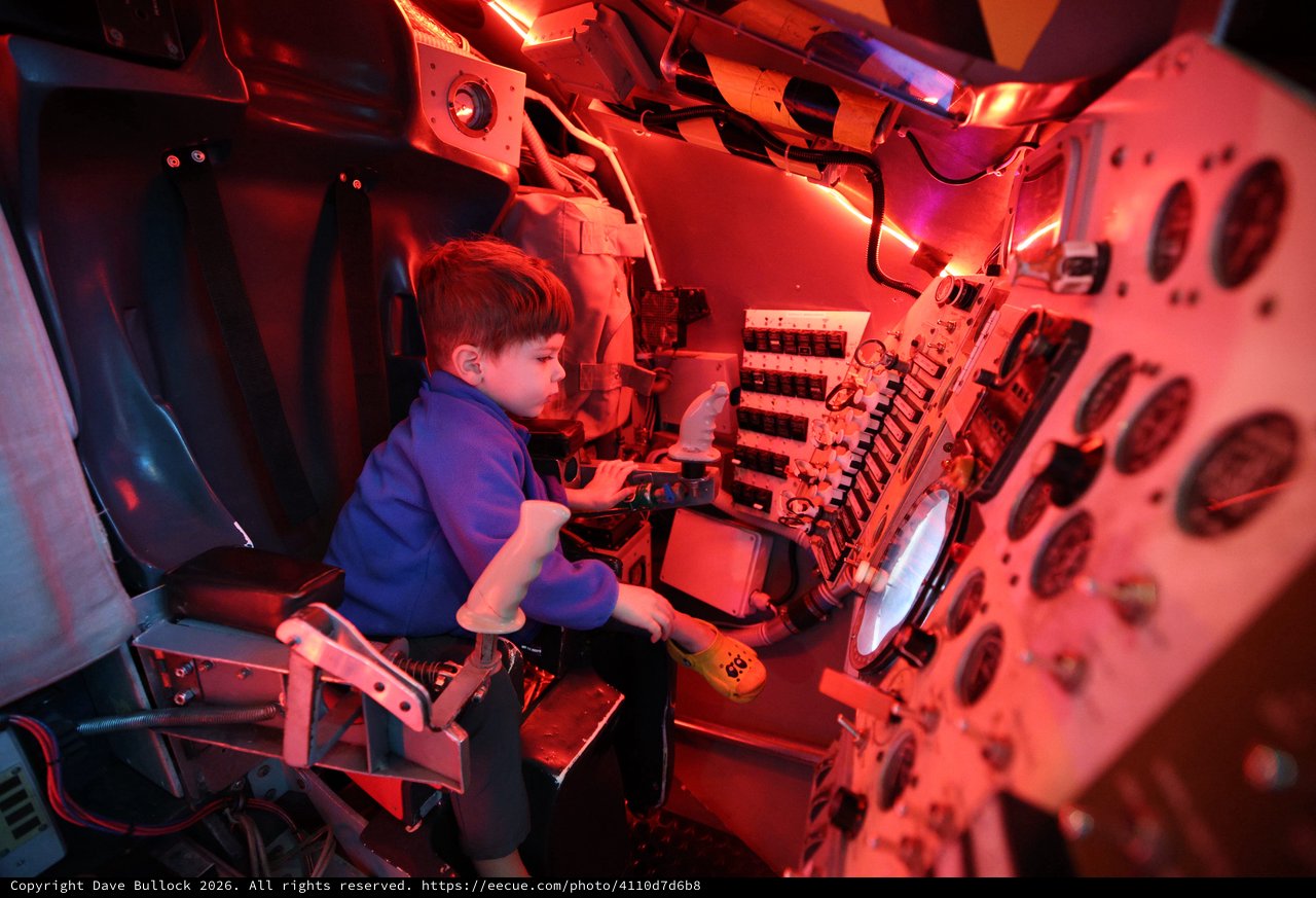 Young Visitor Explores Submarine Control Room Exhibit