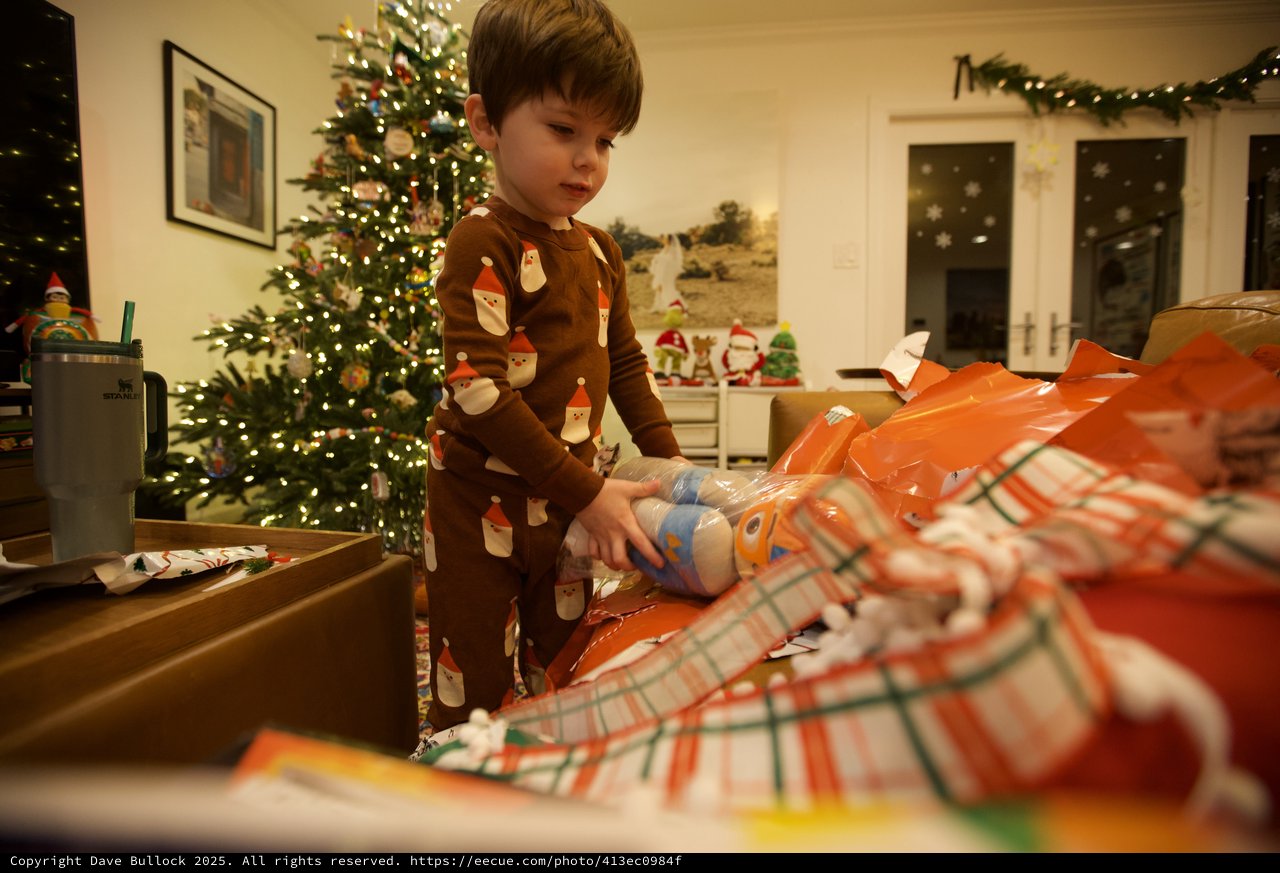 Young Child Opening Christmas Presents on Christmas Morning