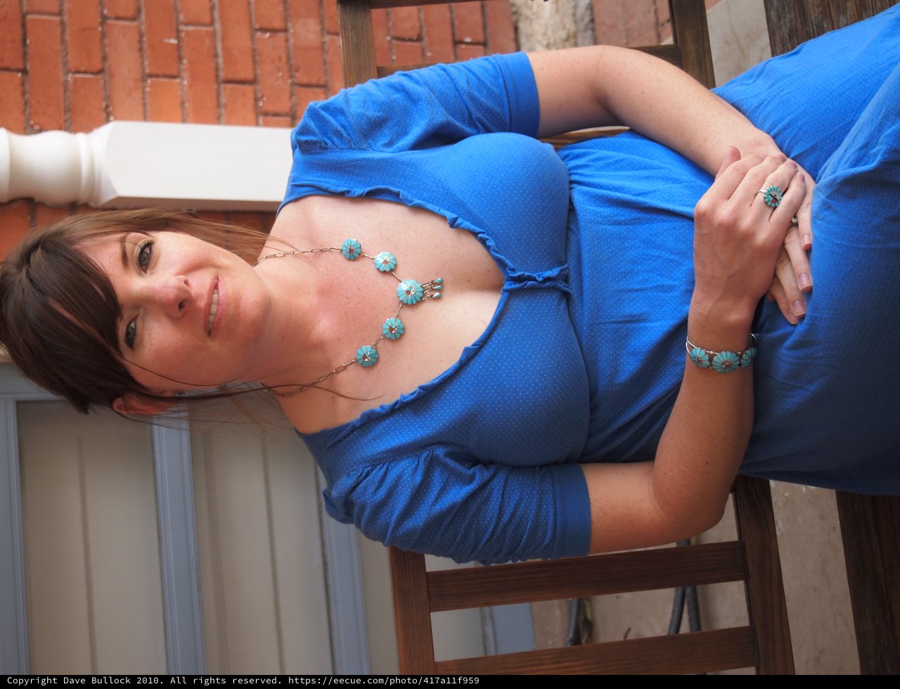Woman in Blue Dress Showcasing Turquoise Jewelry