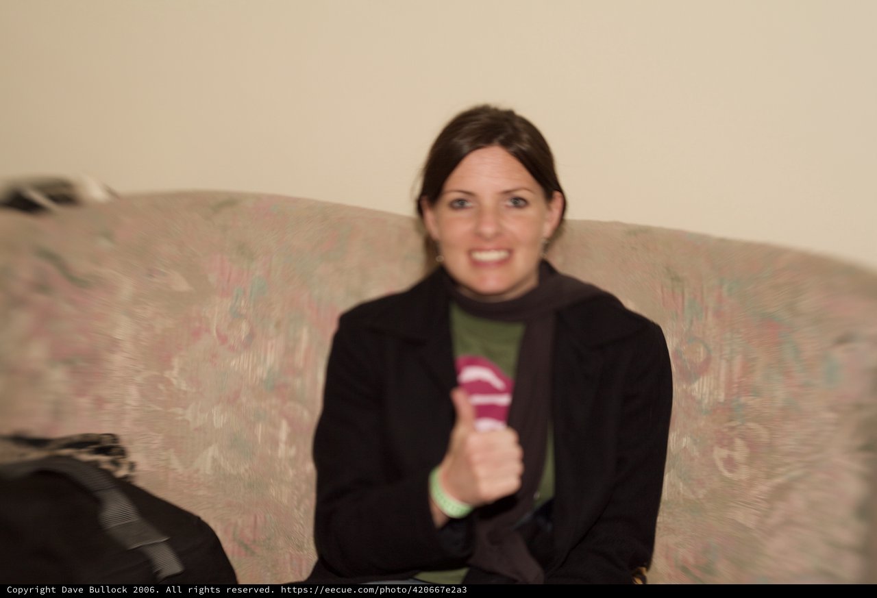 Woman Smiling on Floral Couch Holding Microphone