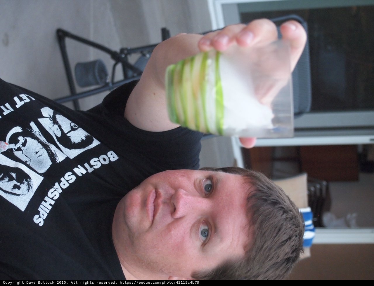 Upside Down Man Holds Green-Striped Drinking Glass