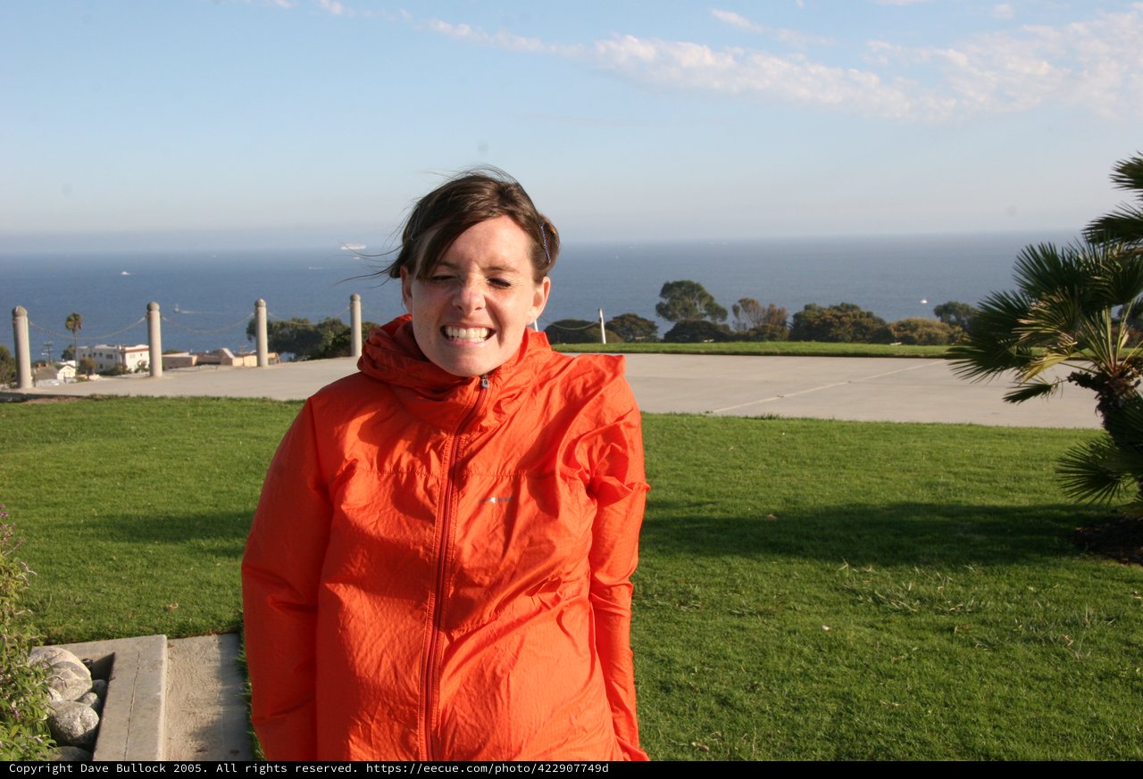 Windswept Woman Smiling at California Coastal Overlook