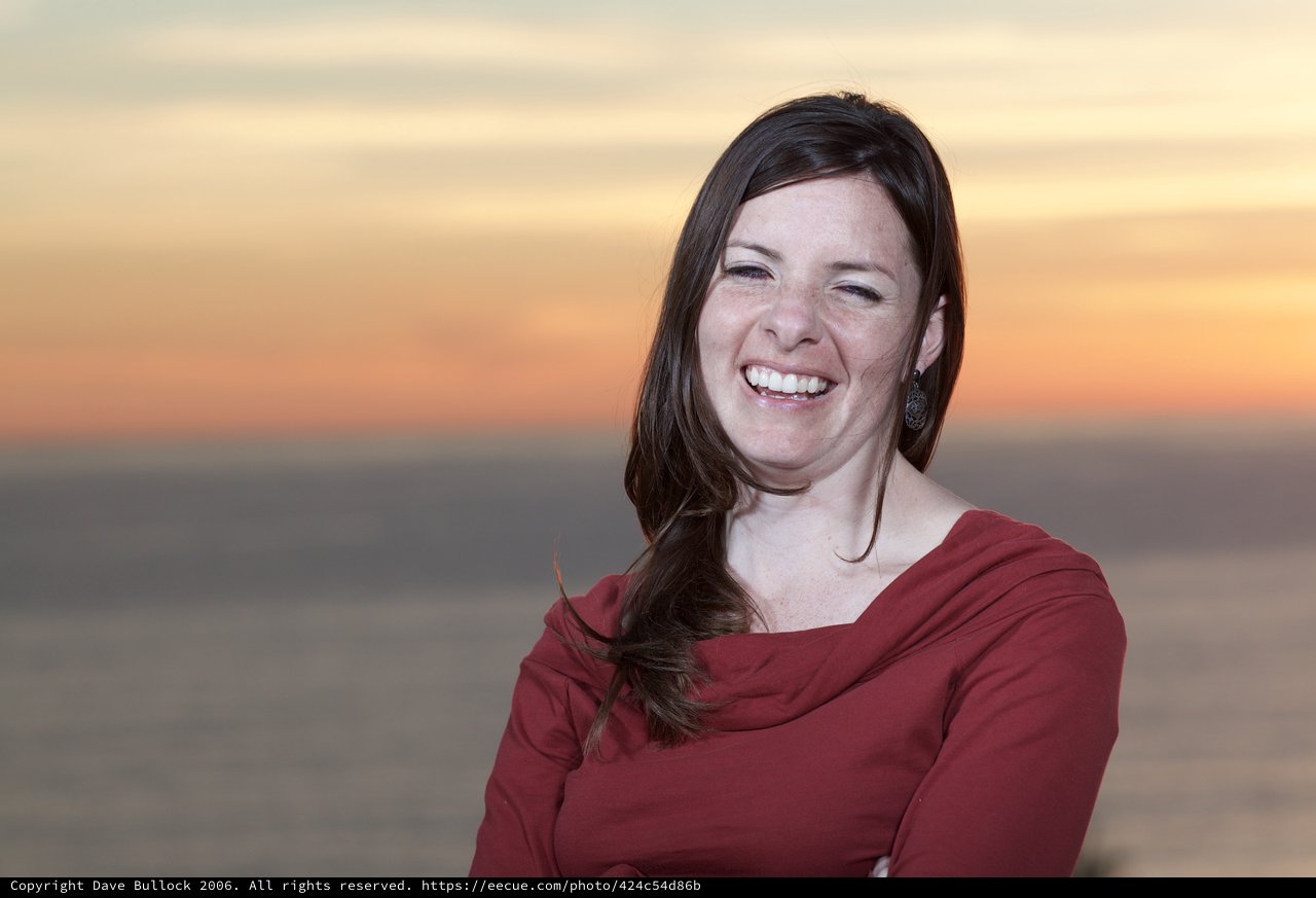 Joyful Woman Laughing at Coastal Sunset