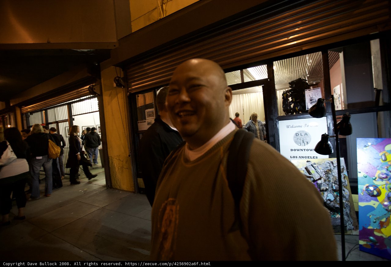 Don Spike Poses with Flooring Sign in Front of Store