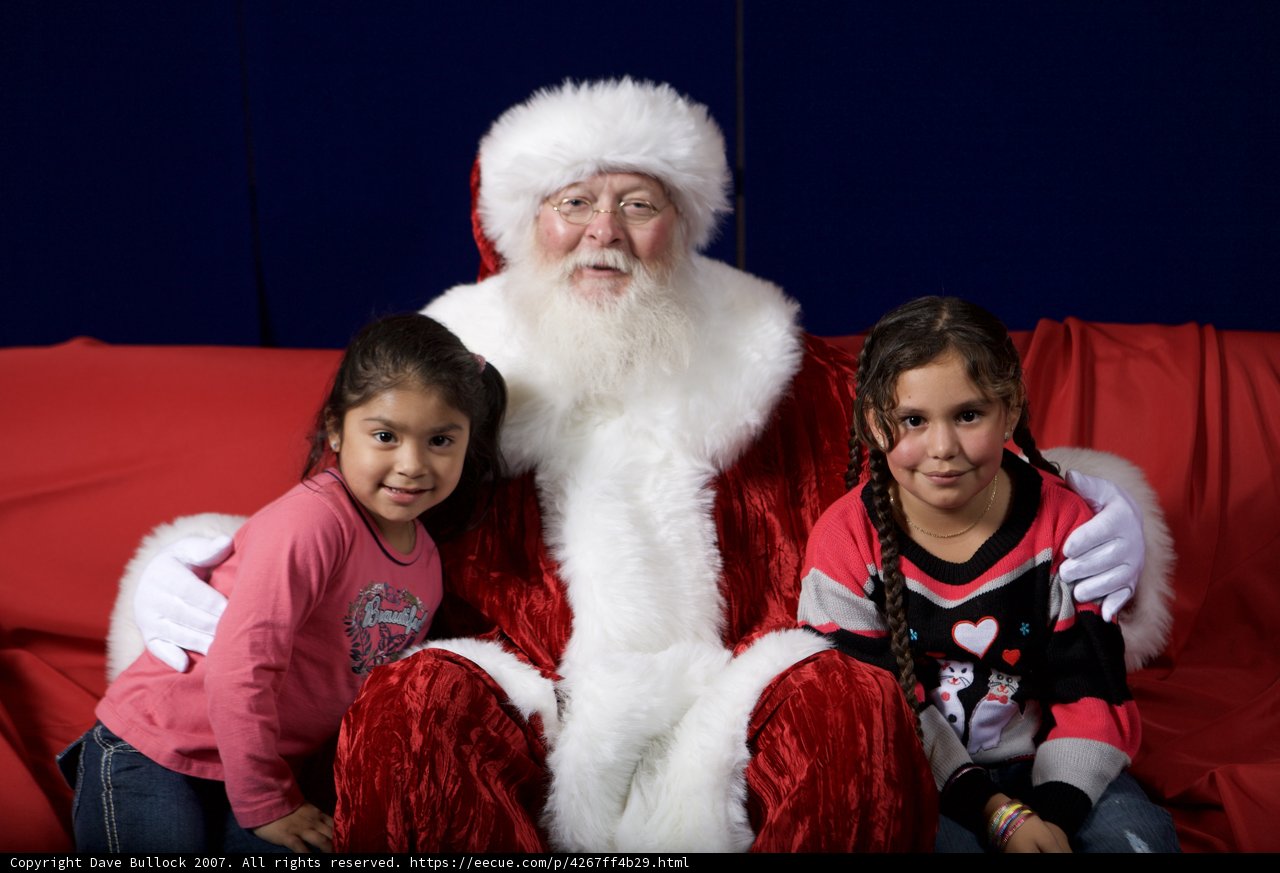 Santa Claus Visits Two Girls on Red Sofa