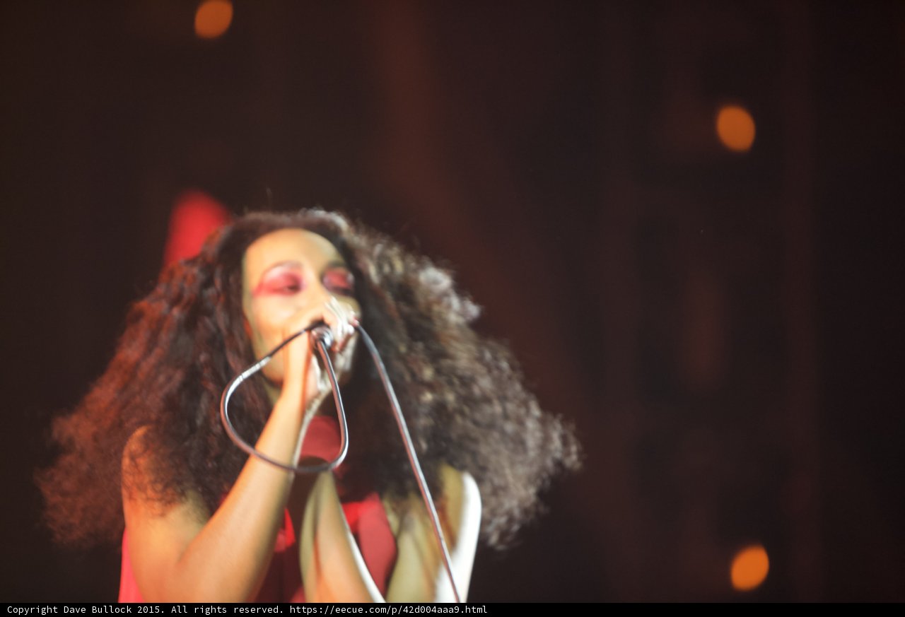 Solange Portrait Eyes Closed Wild Hair Dark Background Orange Bokeh