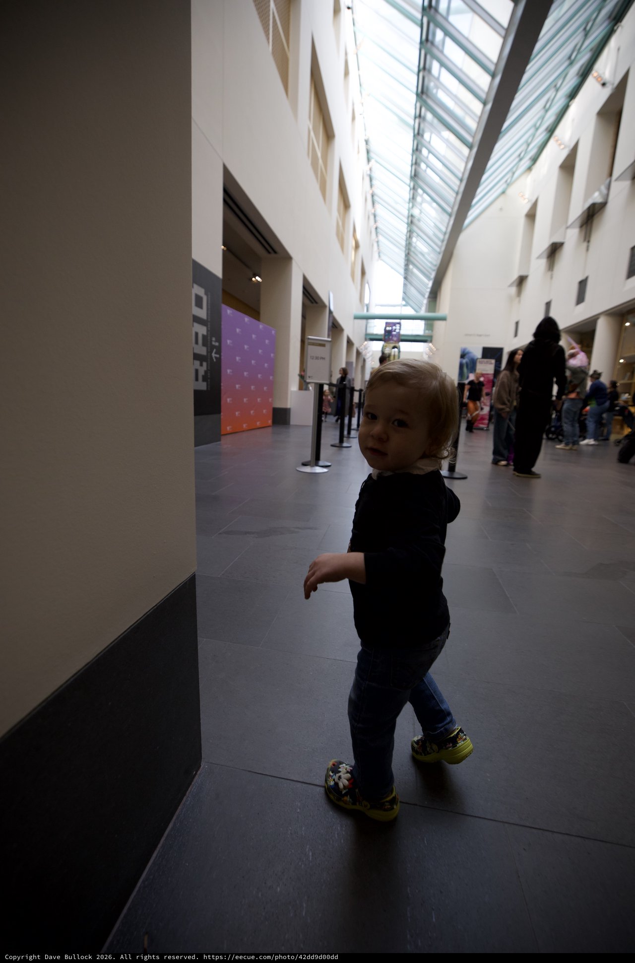 Toddler Exploring Modern Museum Atrium Space