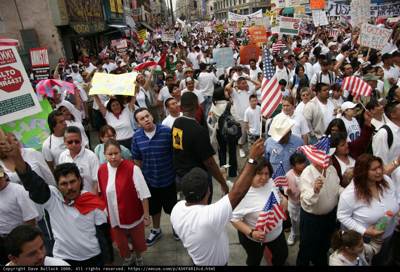 March for America Caption: Lachlan Sharp, Ivana Maria Furtado, Antônio Rogério Nogueira, Jiggy Manicad, Gouher Sultana, and Hayato Tani join a crowd of 63 people at the March for America parade, holding flags and signs for their cause.