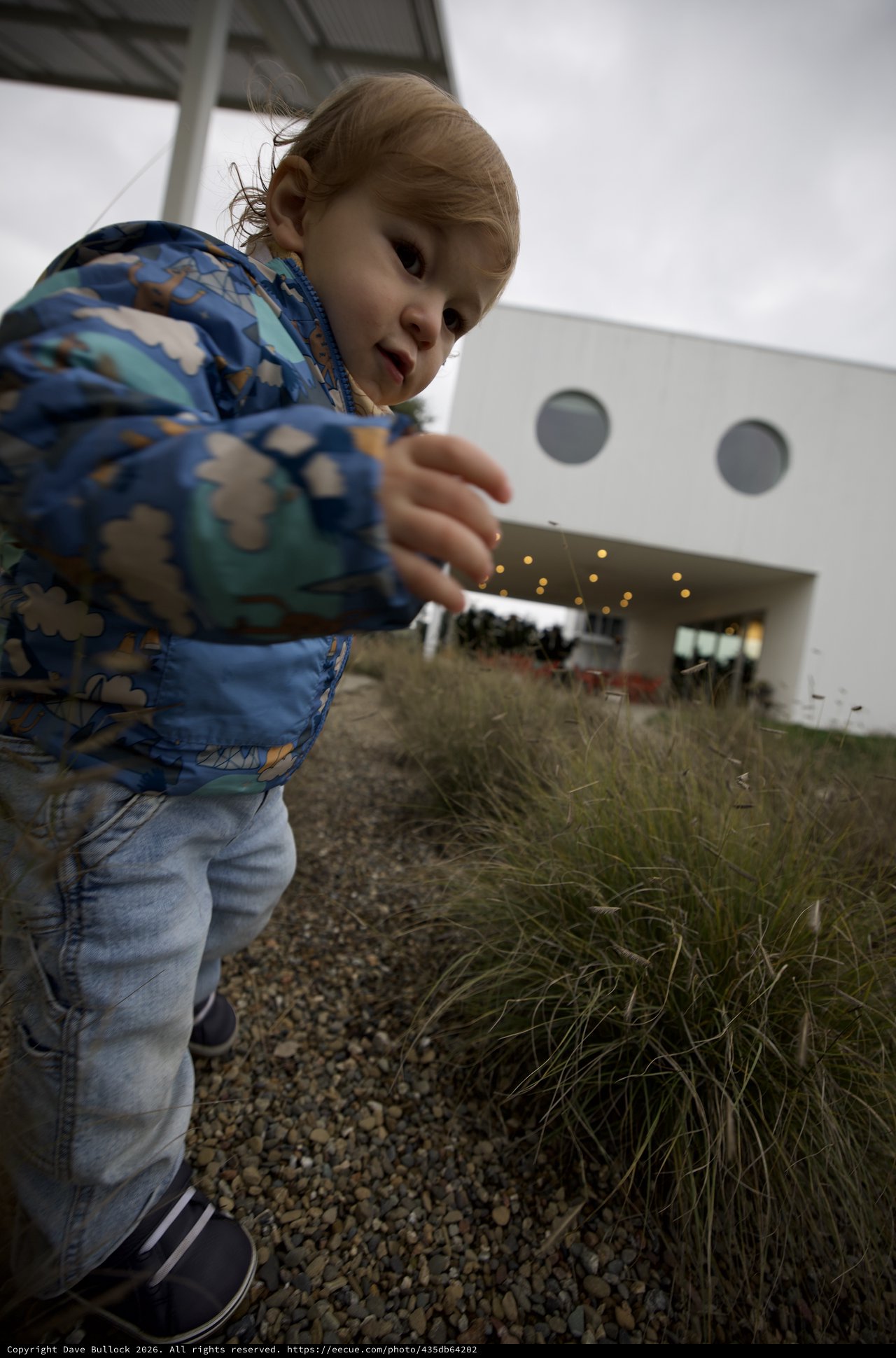 Young Child Playing Giant at Modern Building