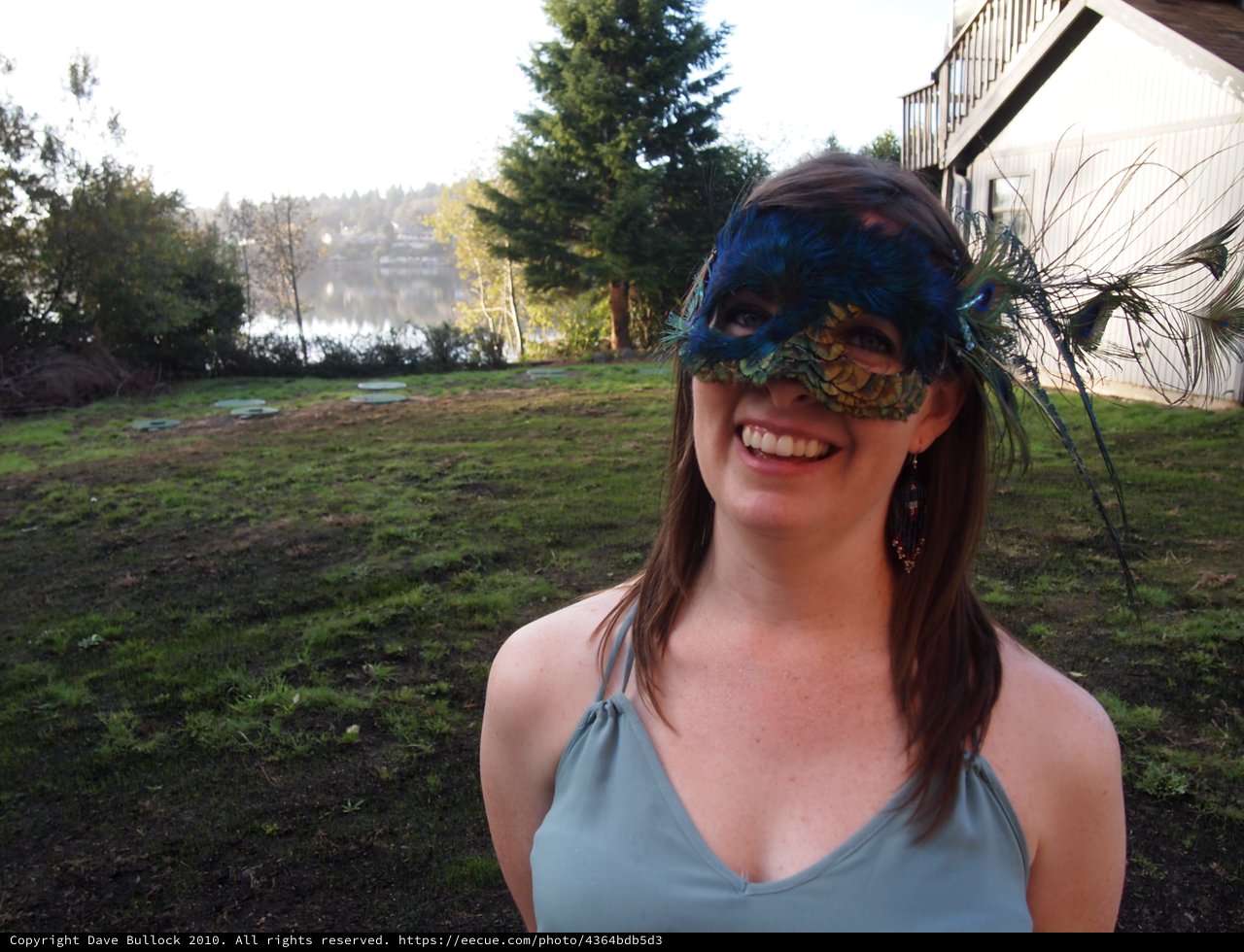 Smiling Woman in Peacock Feather Masquerade Mask