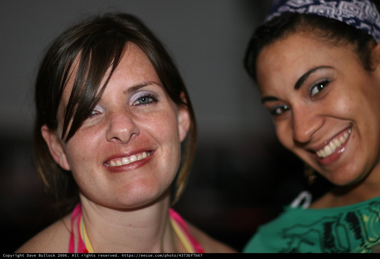 Two Smiling Women Posing Together at Social Event