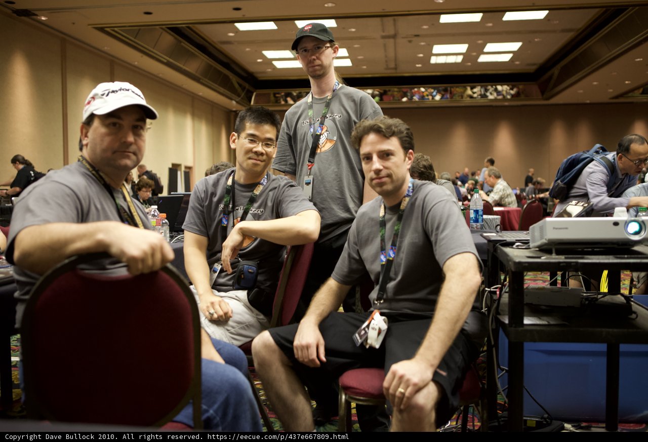Four Men in Hats Sitting on Chairs