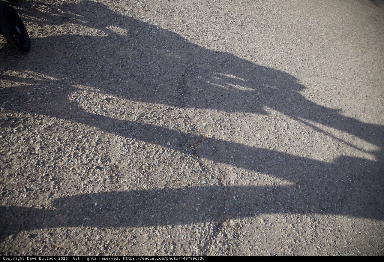 Shadow of a Child on Textured Pavement