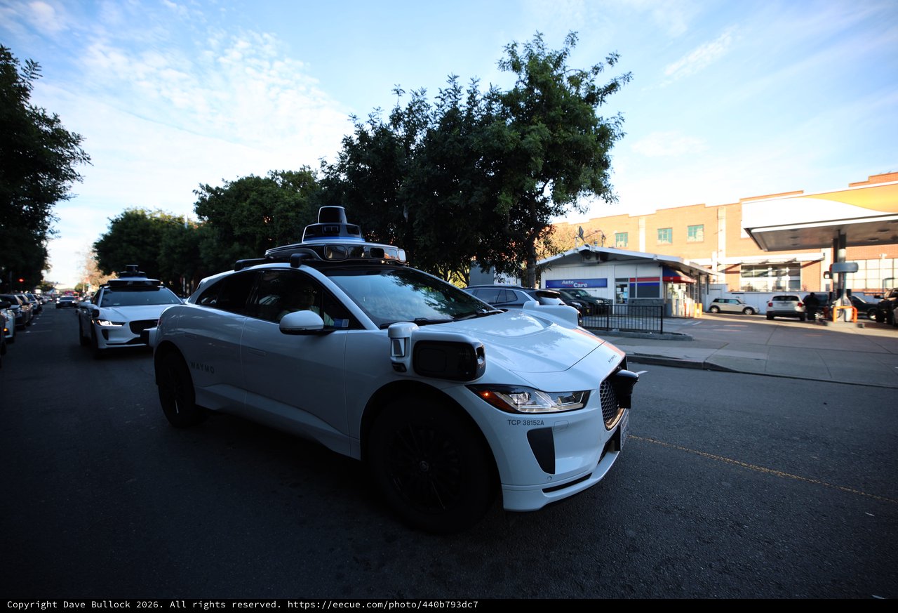 Autonomous Waymo Vehicle on Urban Street at Dusk