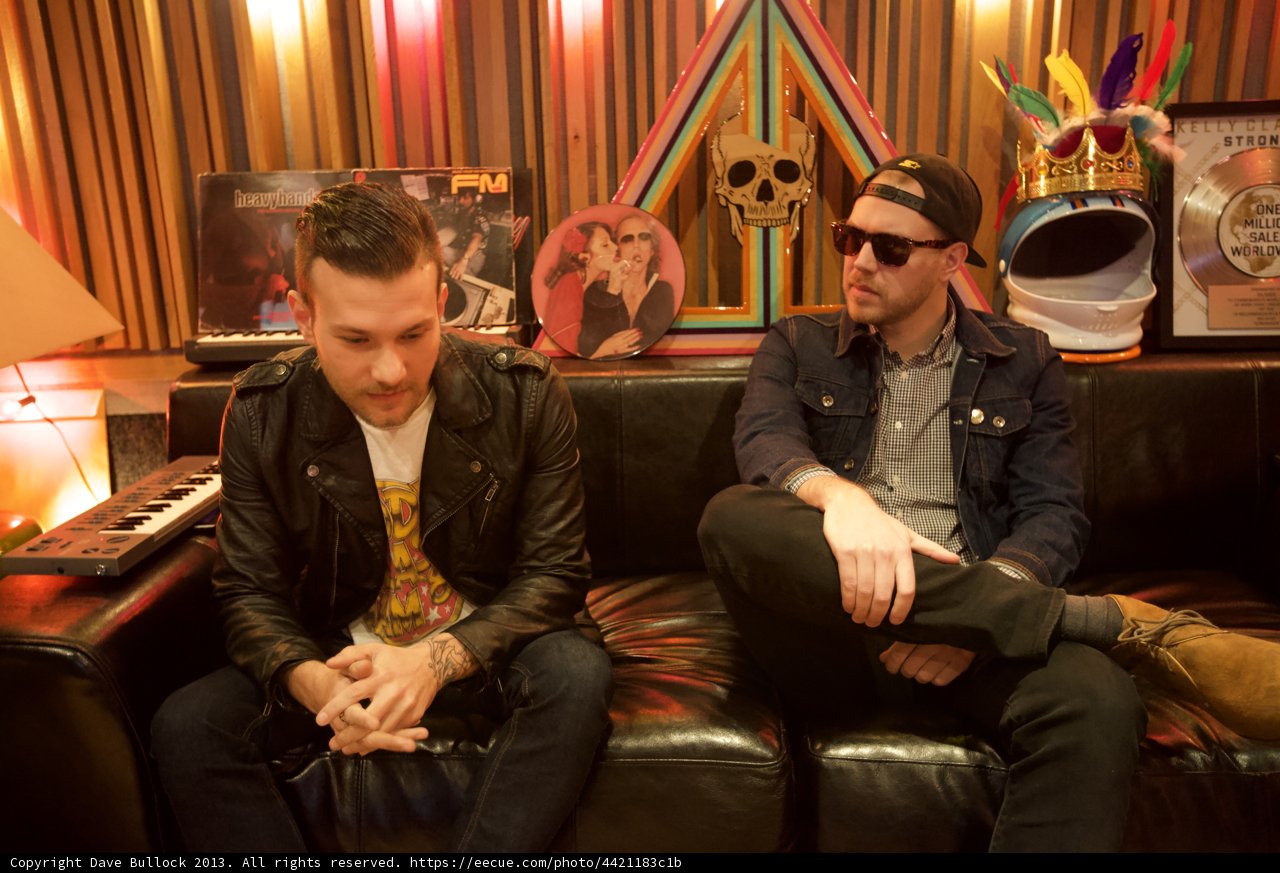 Two Men Relaxing on a Cozy Couch in Their Living Room