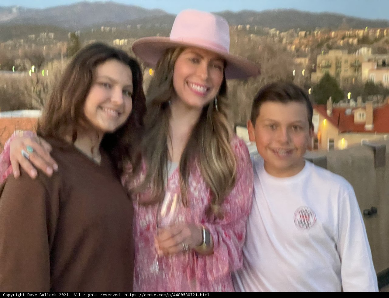 Three People Strike a Pose with Mountains in the Distance