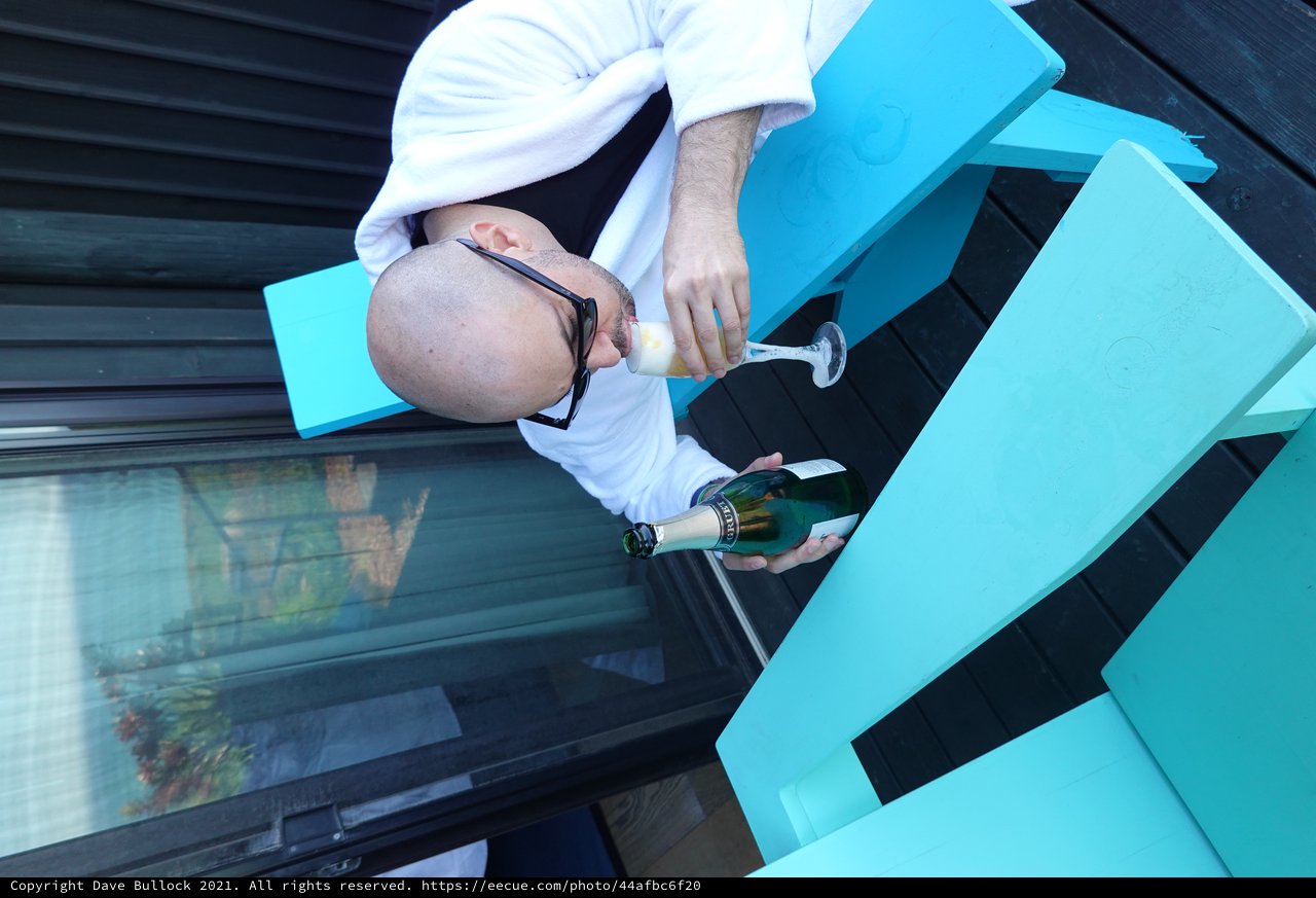 Man Enjoying Champagne on Turquoise Outdoor Furniture