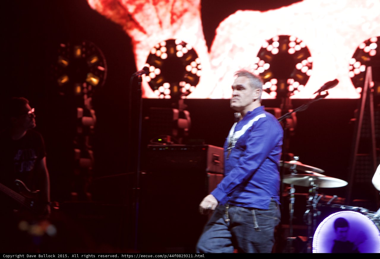 Morrissey Wide Stance Looking Back Blue Shirt Red Video Screen Gold Lights Bassist Drums