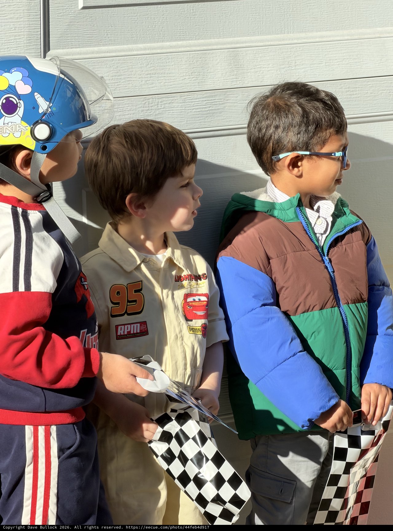Young Racing Fans with Checkered Flags and Costumes