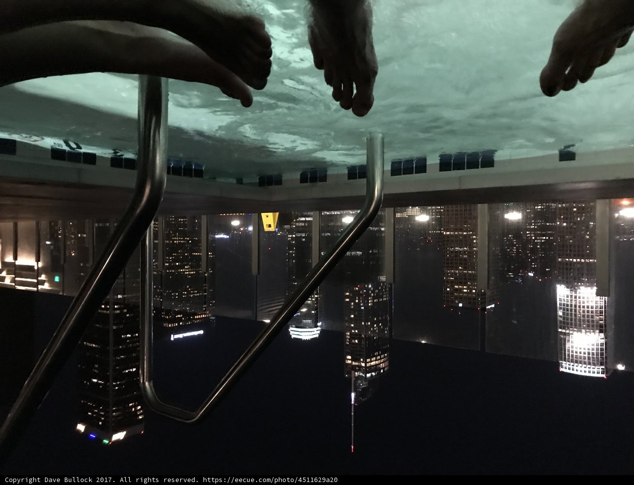 Nighttime Reflections in the City Caption: The serene waters of the jacuzzi provide the perfect spot for some peaceful reflection amidst the towering skyscrapers of the urban metropolis.