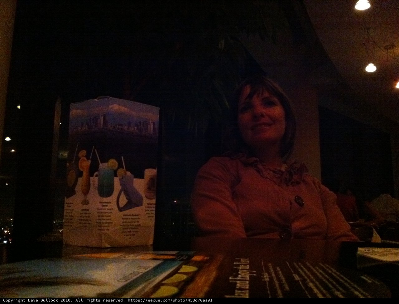Smiling Woman at Dimly Lit Restaurant Table