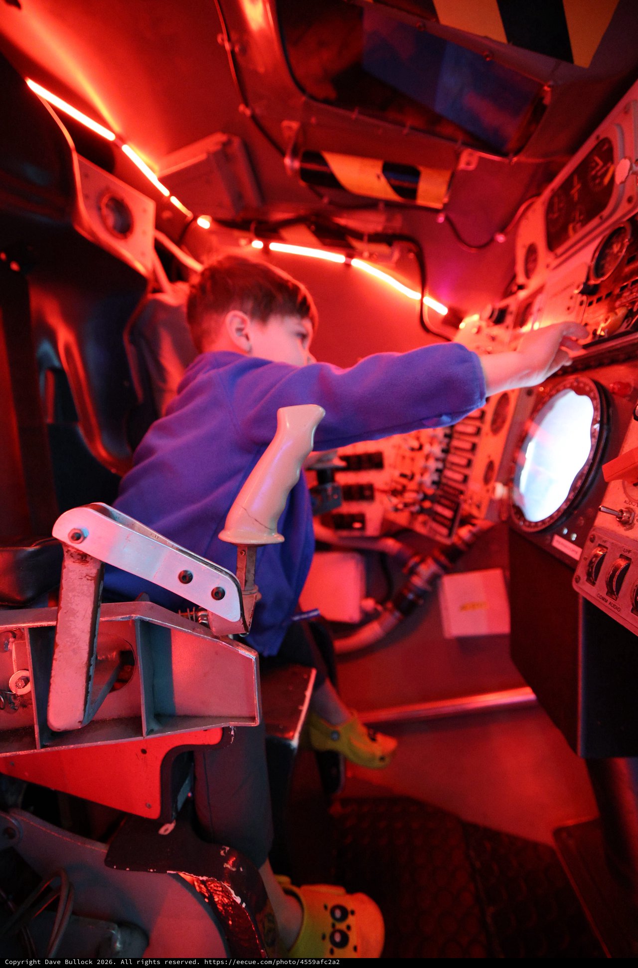 Young Astronaut Training in Red-Lit Space Capsule Simulator