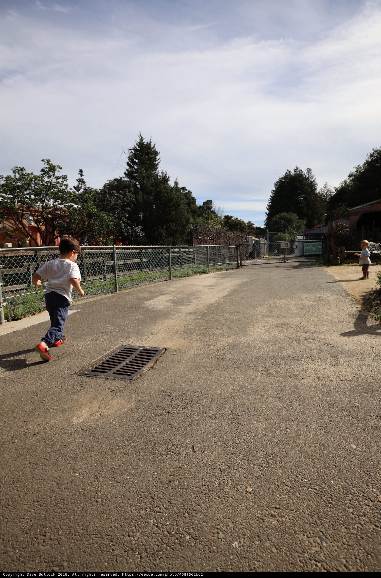 Children Running on Playground Pathway at Dusk