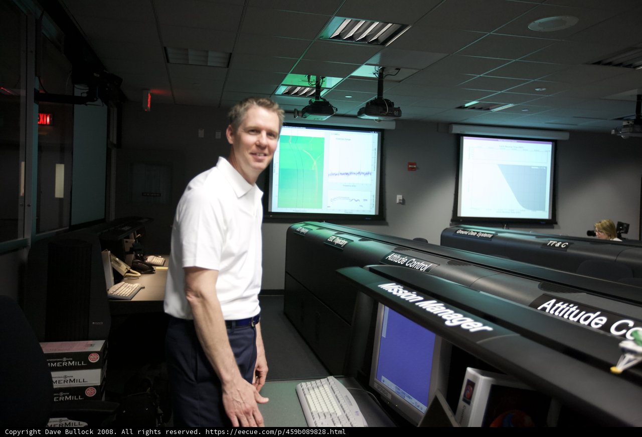 Man Standing in Front of Computer Monitors