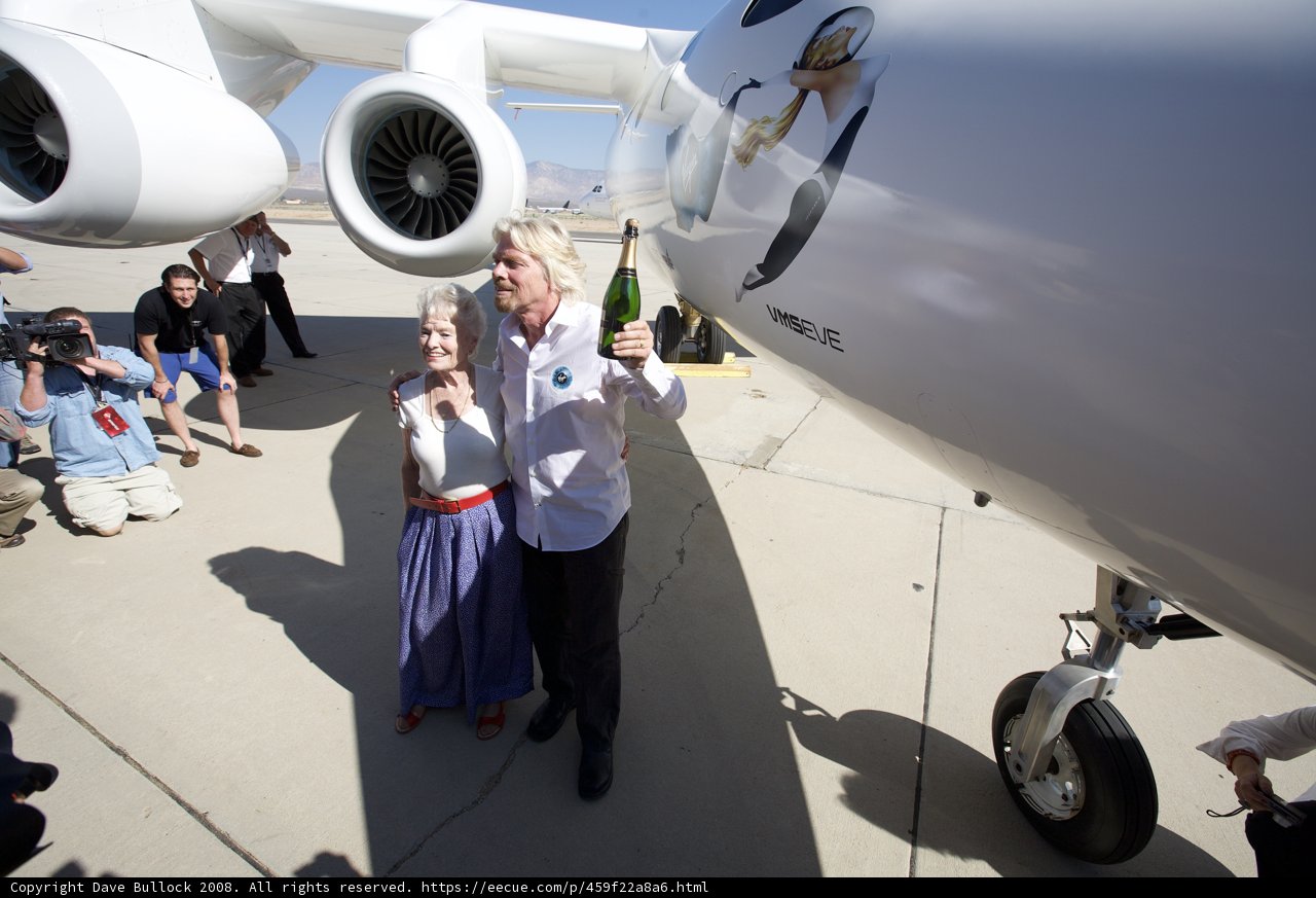 Richard Branson and a Woman Pose with Aircraft on Airfield