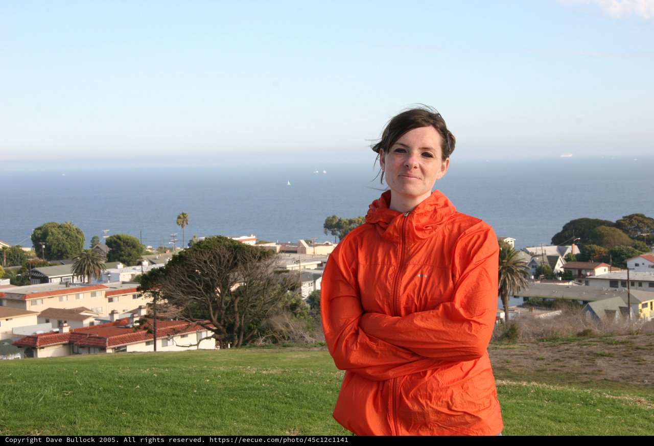 Woman in Orange Jacket Overlooking Coastal California Town