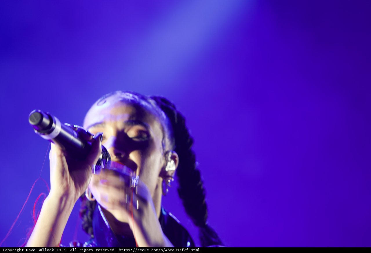 FKA twigs Emotional Portrait Eyes Closed Baby Hairs Hoop Earrings Red Lipstick Braided Ponytails Black Choker Both Hands Holding Microphone Rings Kimono Purple Blue Lighting