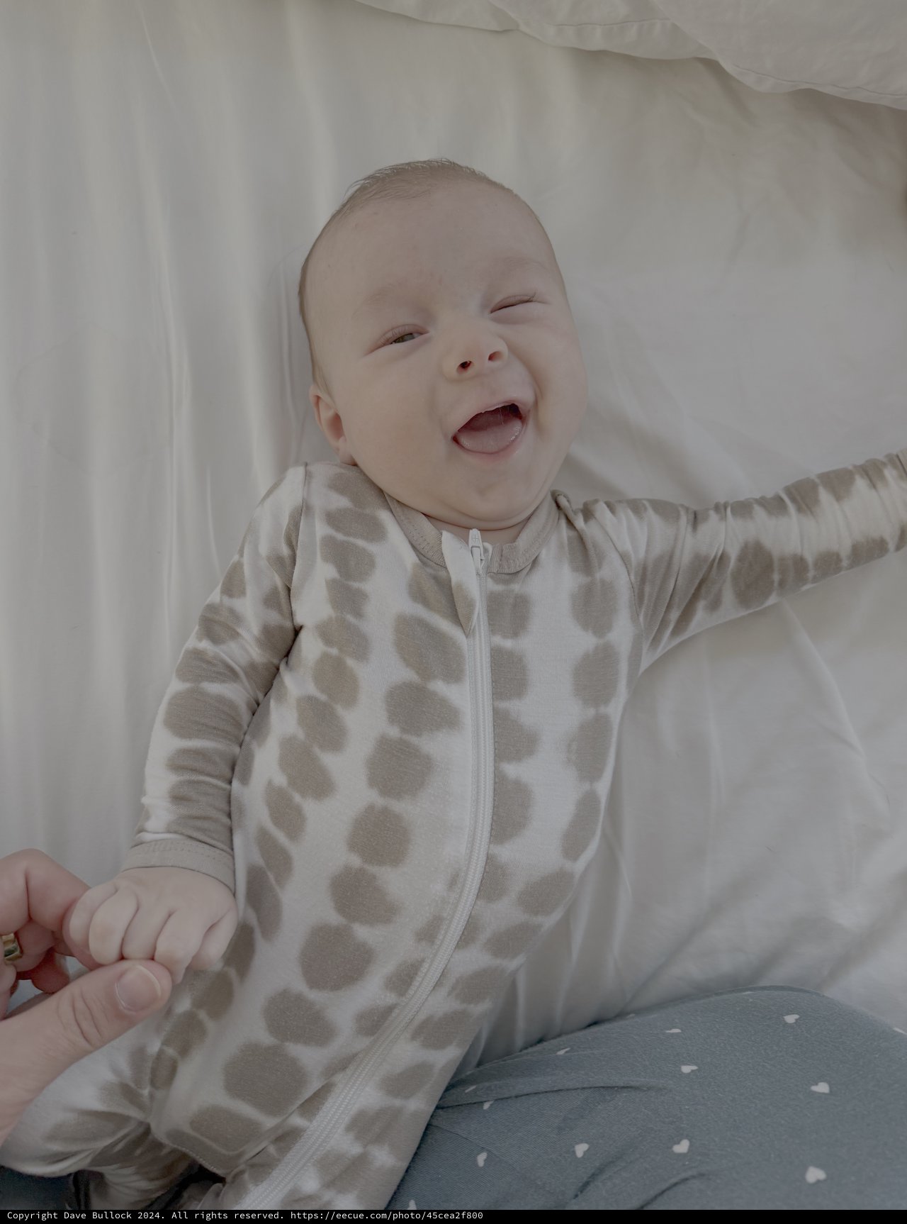 Joyful Baby Laughing in Polka Dot Onesie