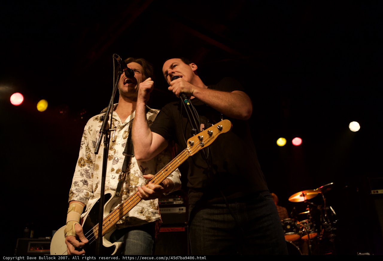 Rocking the Stage: 2 Men Singing into Microphones