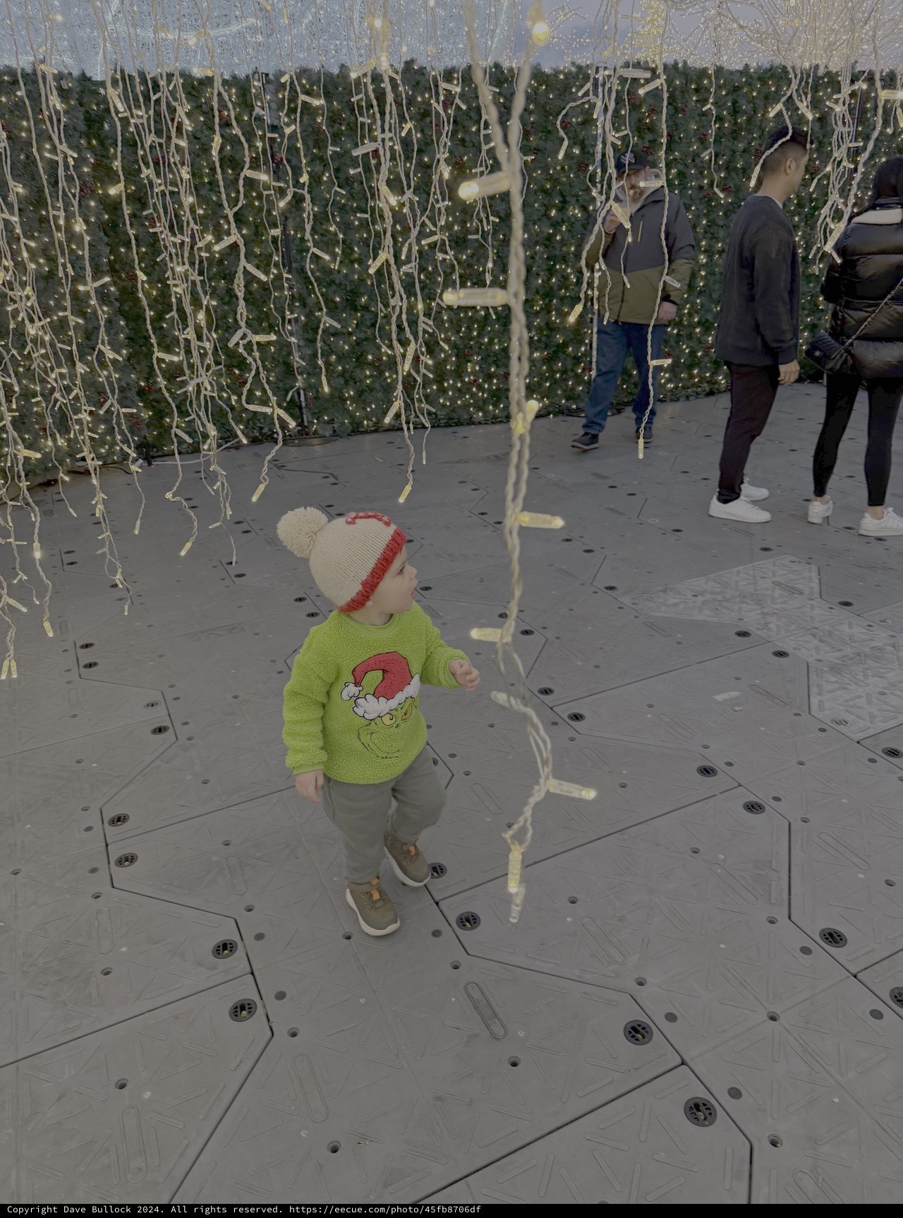 Child Plays Among Festive Holiday Light Decorations
