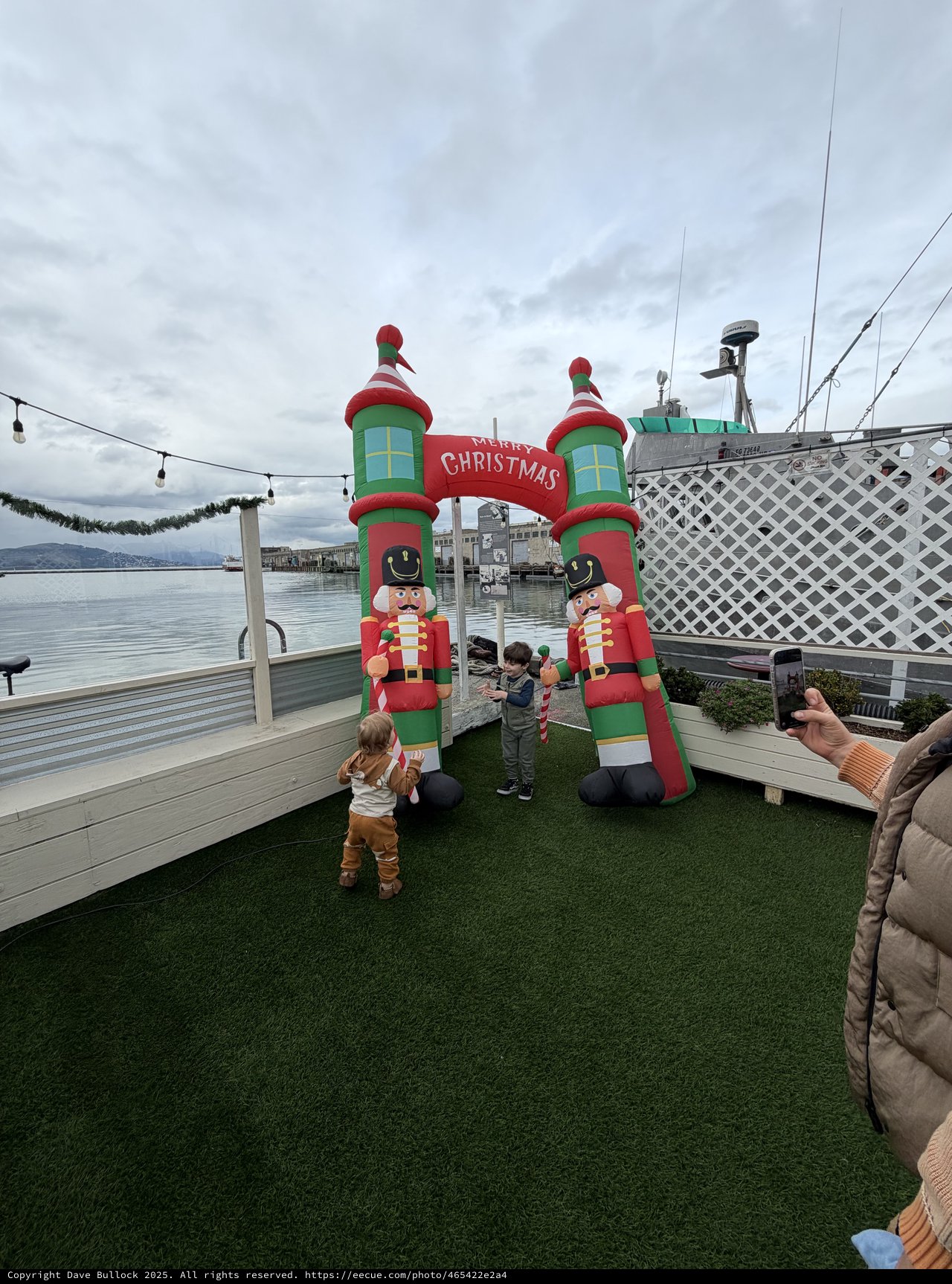 Children with Giant Inflatable Christmas Nutcrackers by the Water