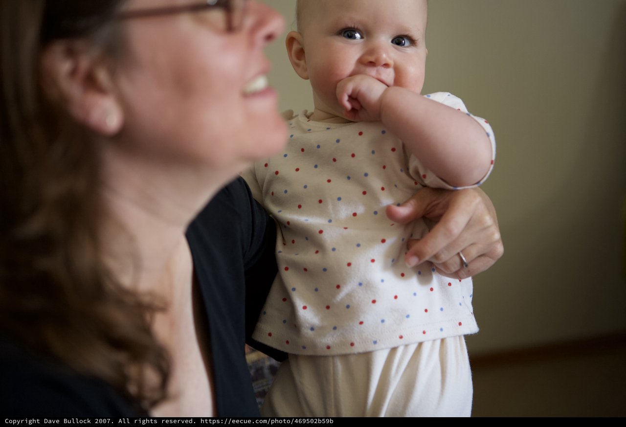 Joyful Mother Holds Smiling Baby in Polka Dots