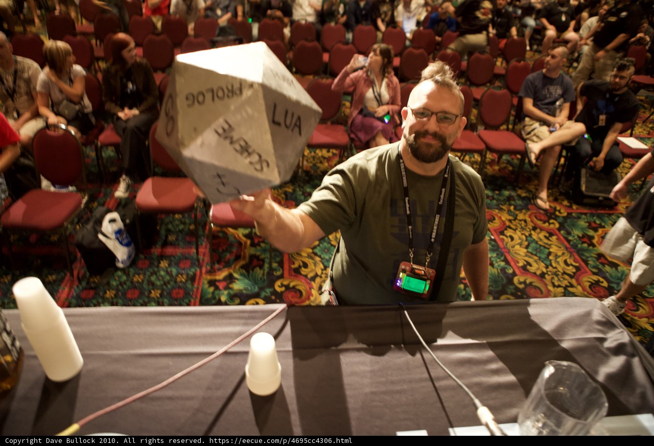 Man Holds Mystery Object in Front of Excited Crowd