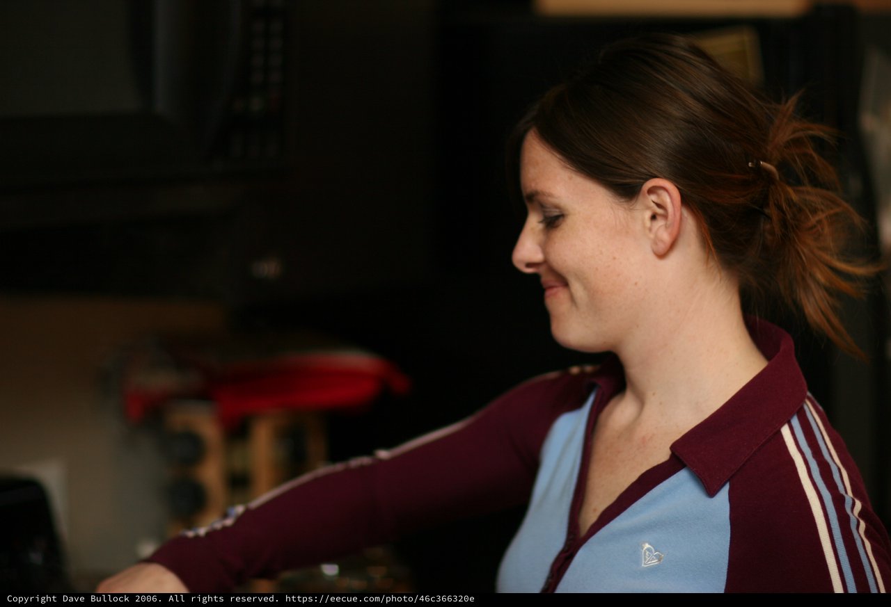 Woman Smiling in Profile at Indoor Gathering