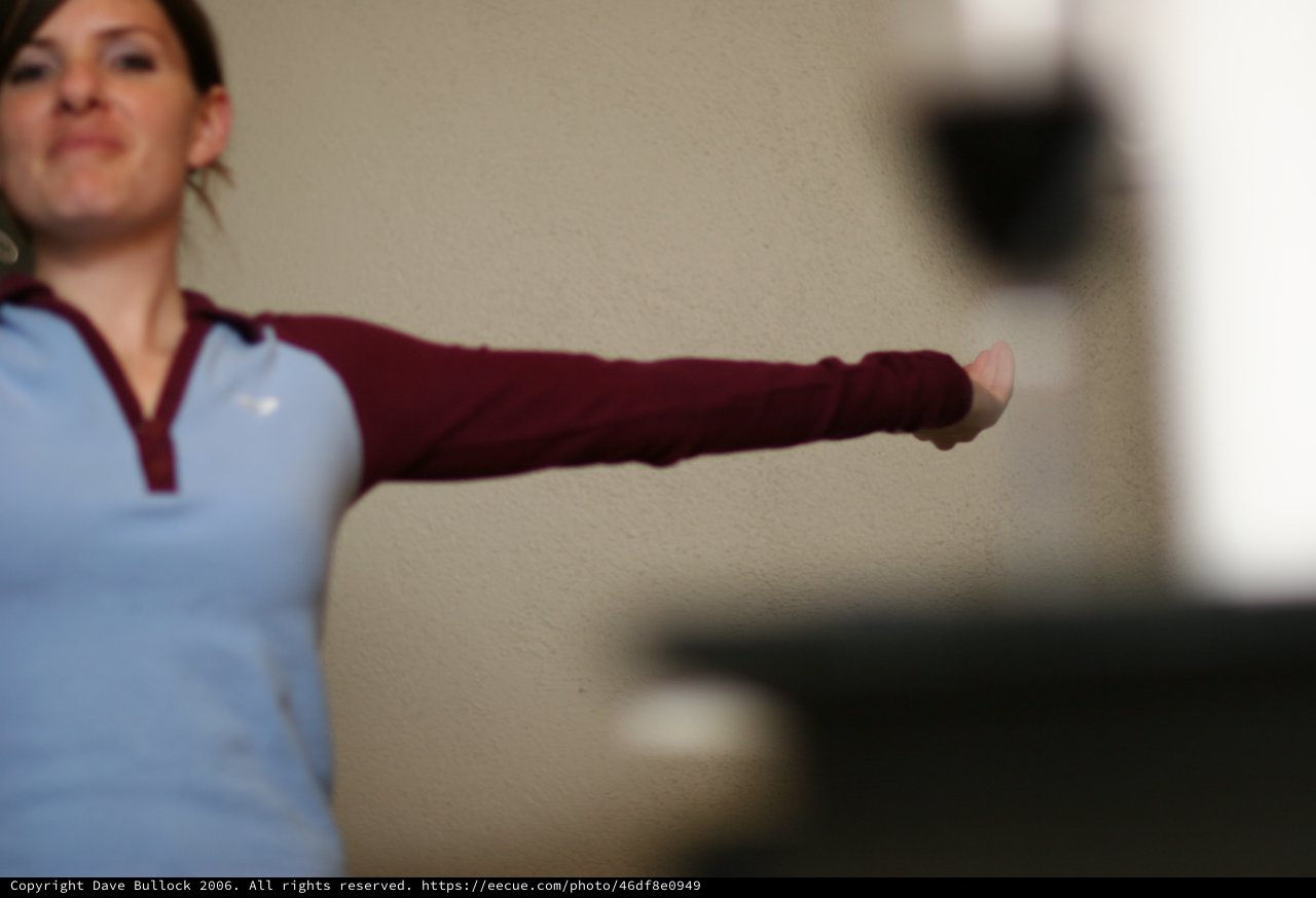 Woman Extends Fist in Focused Indoor Training Pose