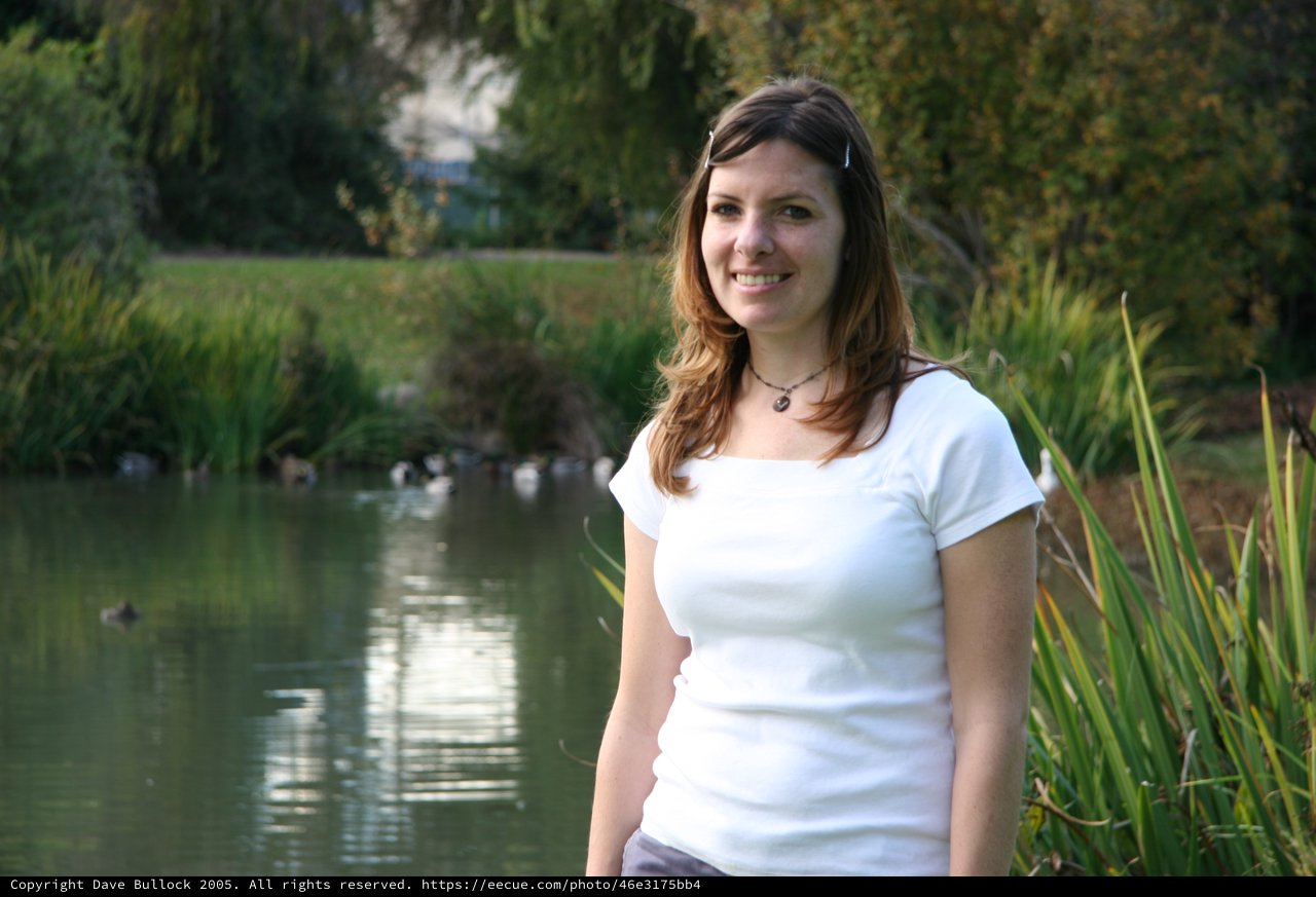 Smiling Woman by a Peaceful Park Pond