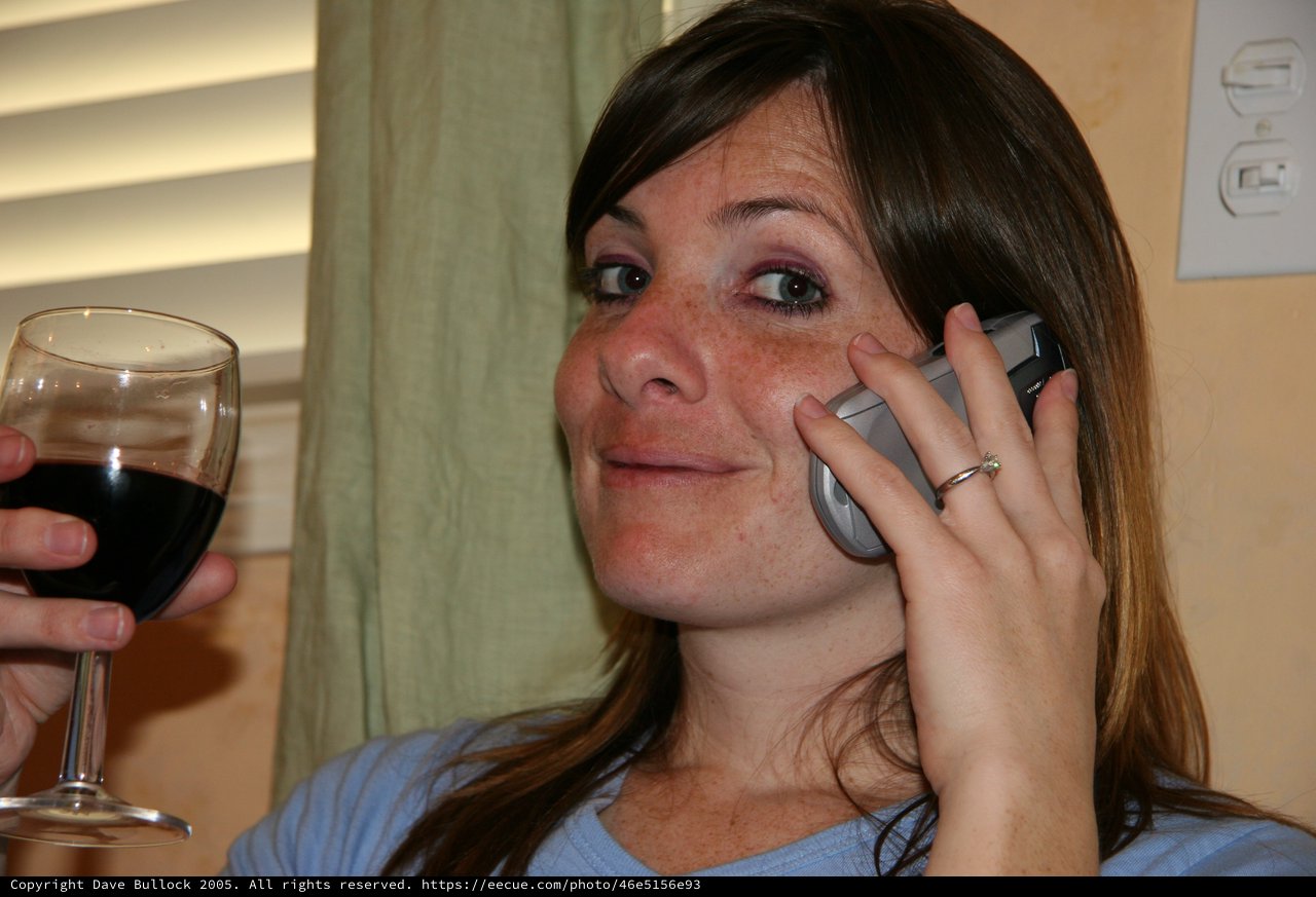 Young Woman on Phone with Glass of Red Wine