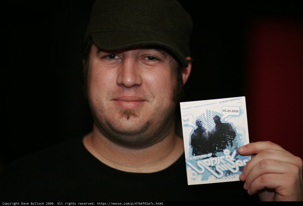 Man with Baseball Cap Holding Card