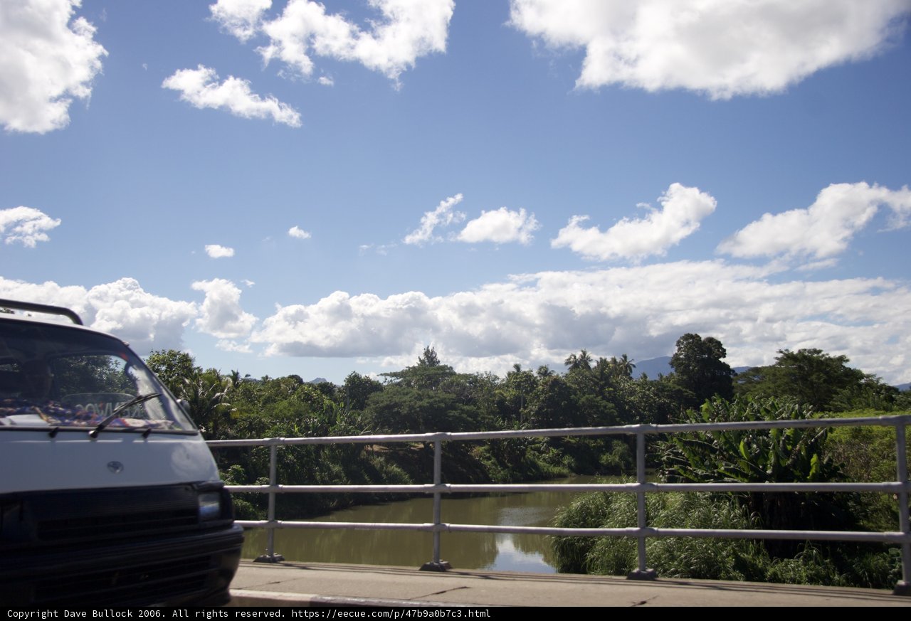 White Van Crossing Bridge with Blue Skies