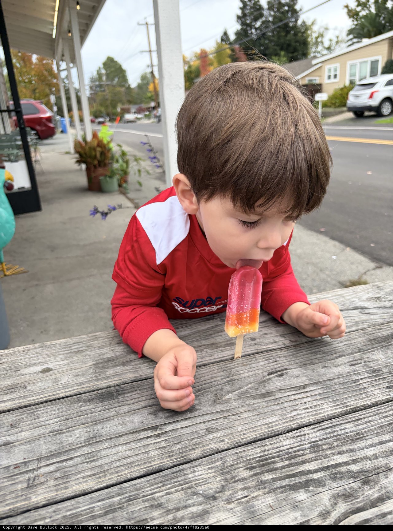 Young Boy Enjoying a Popsicle on a Small Town Street