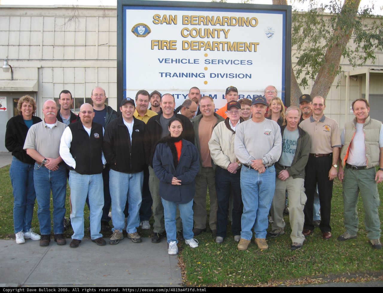 Group of People Poses in Front of Sign