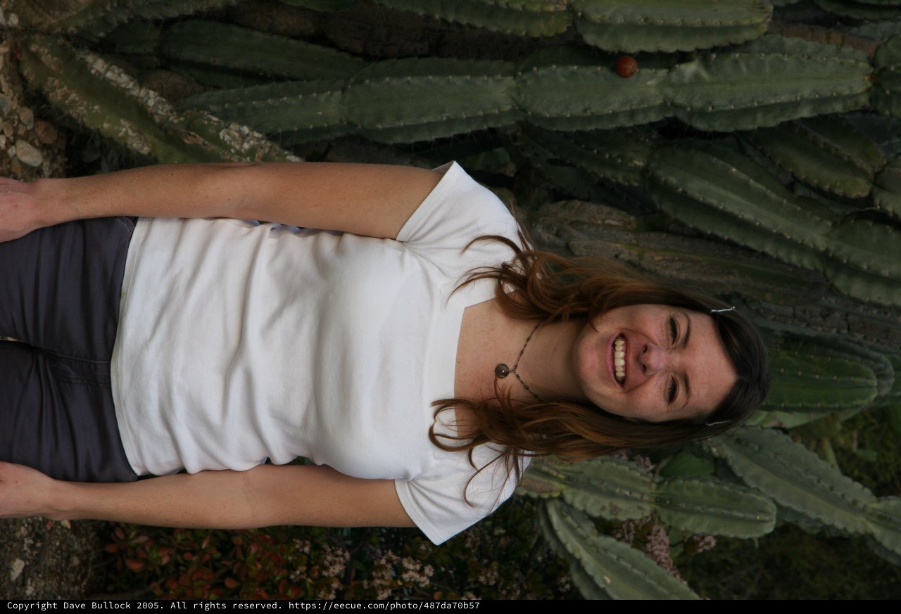 Smiling Woman Laughing Before Giant Cactus Wall