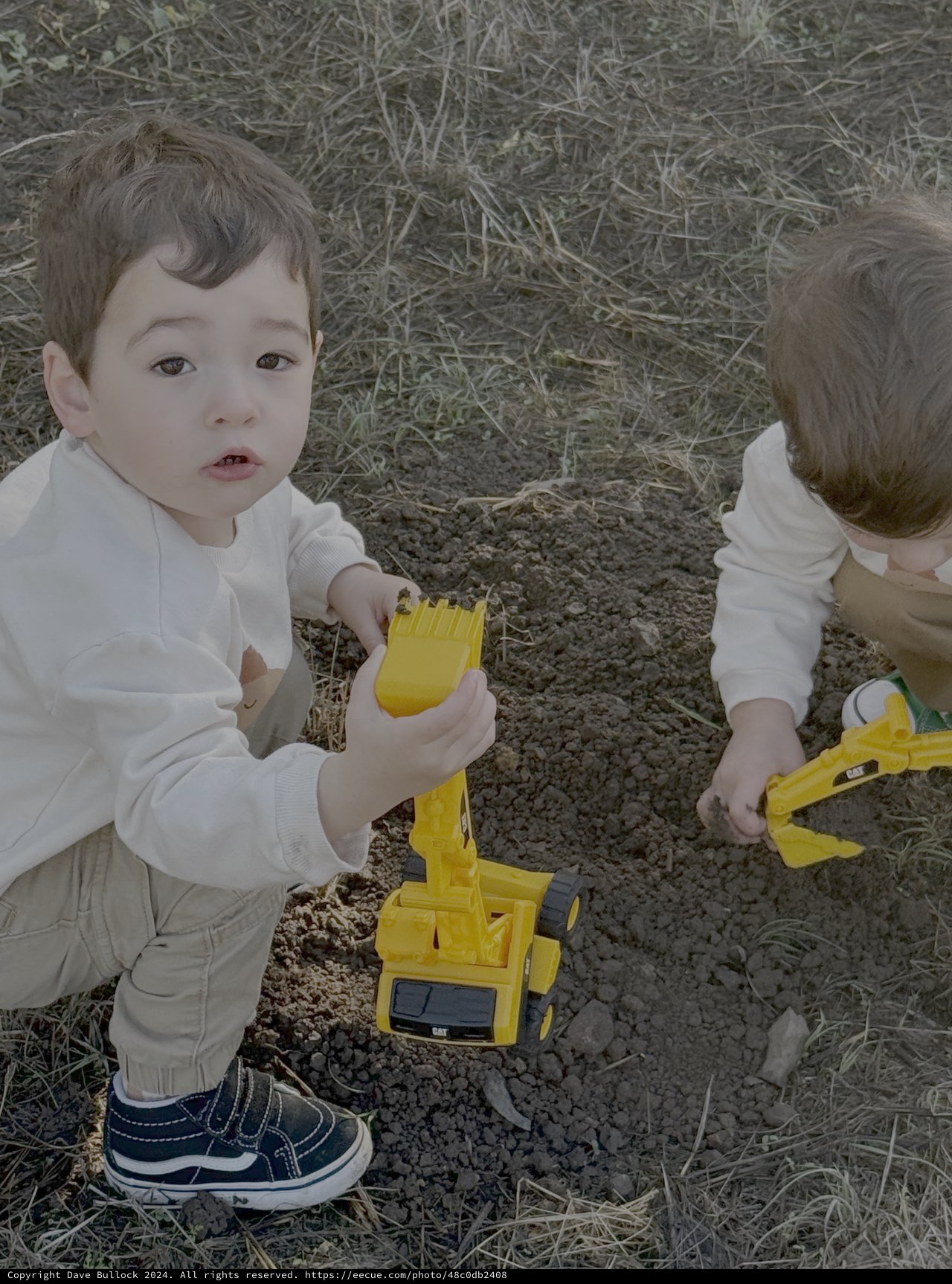 Children Playing with Toy Construction Trucks Outdoors